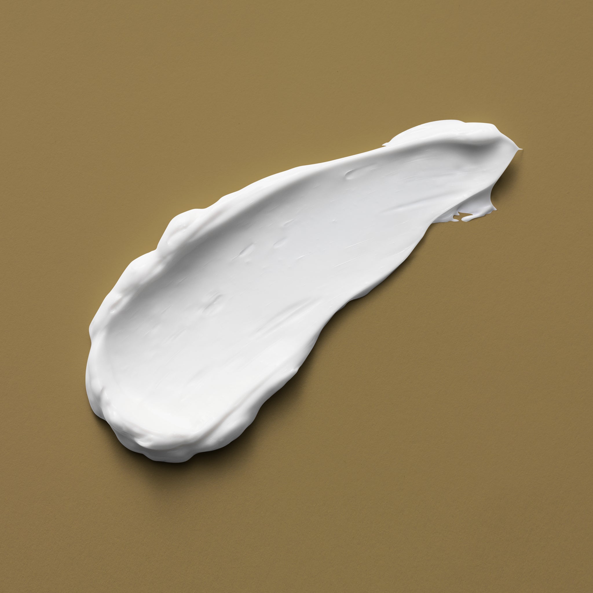 A smear of bright white cream on a light brown background