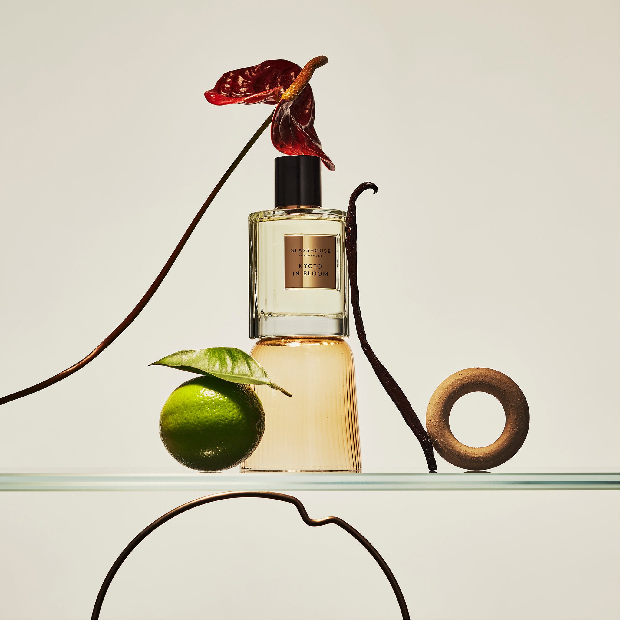 Glasshouse Fragrances Kyoto In Bloom Camellia and Lotus Eau de Parfum sittiing on glass shelf with citrus and floral decoration