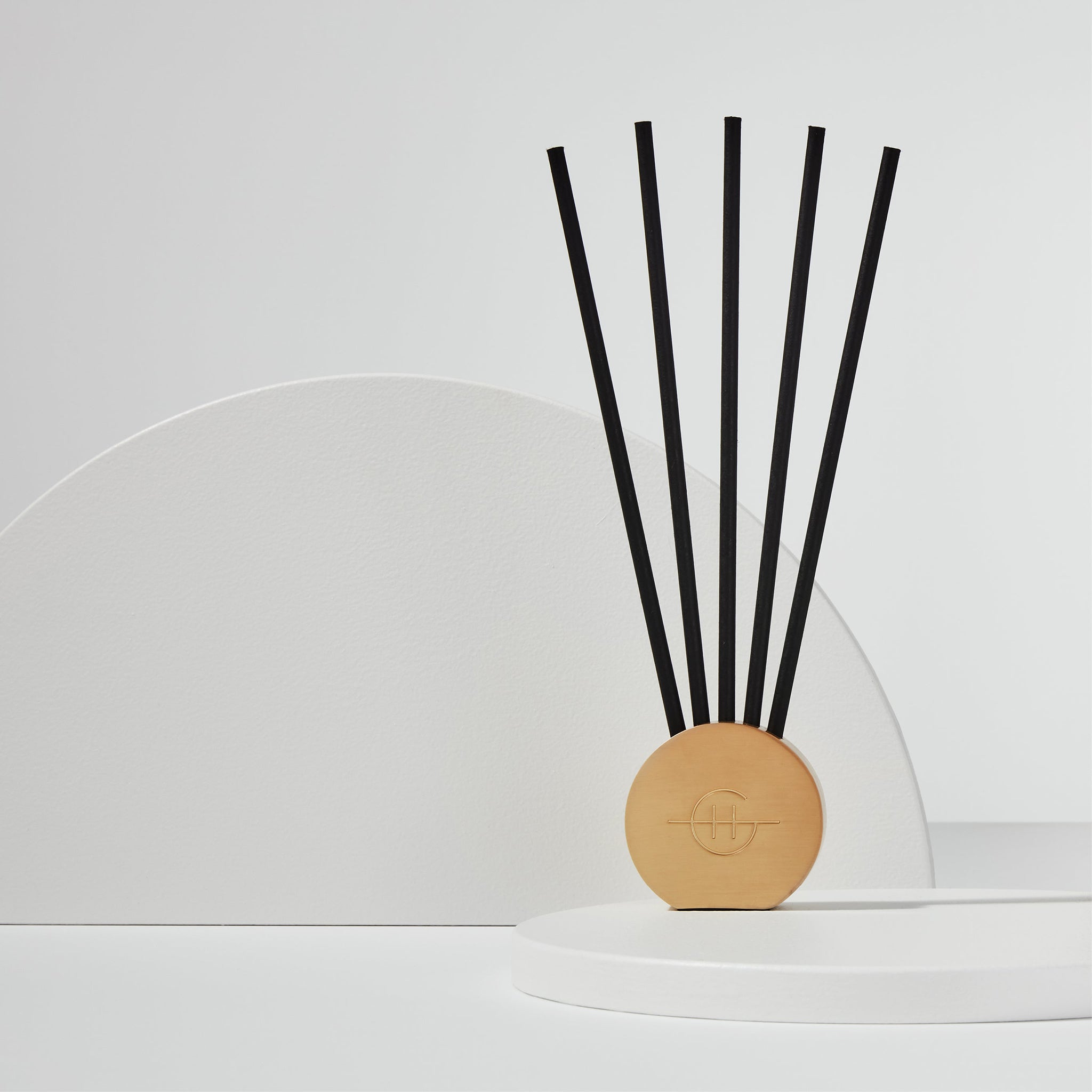 Glasshouse Fragrances Scent Scene™ Liquidless Diffuser metal stand and scent stems on a white tabletop 