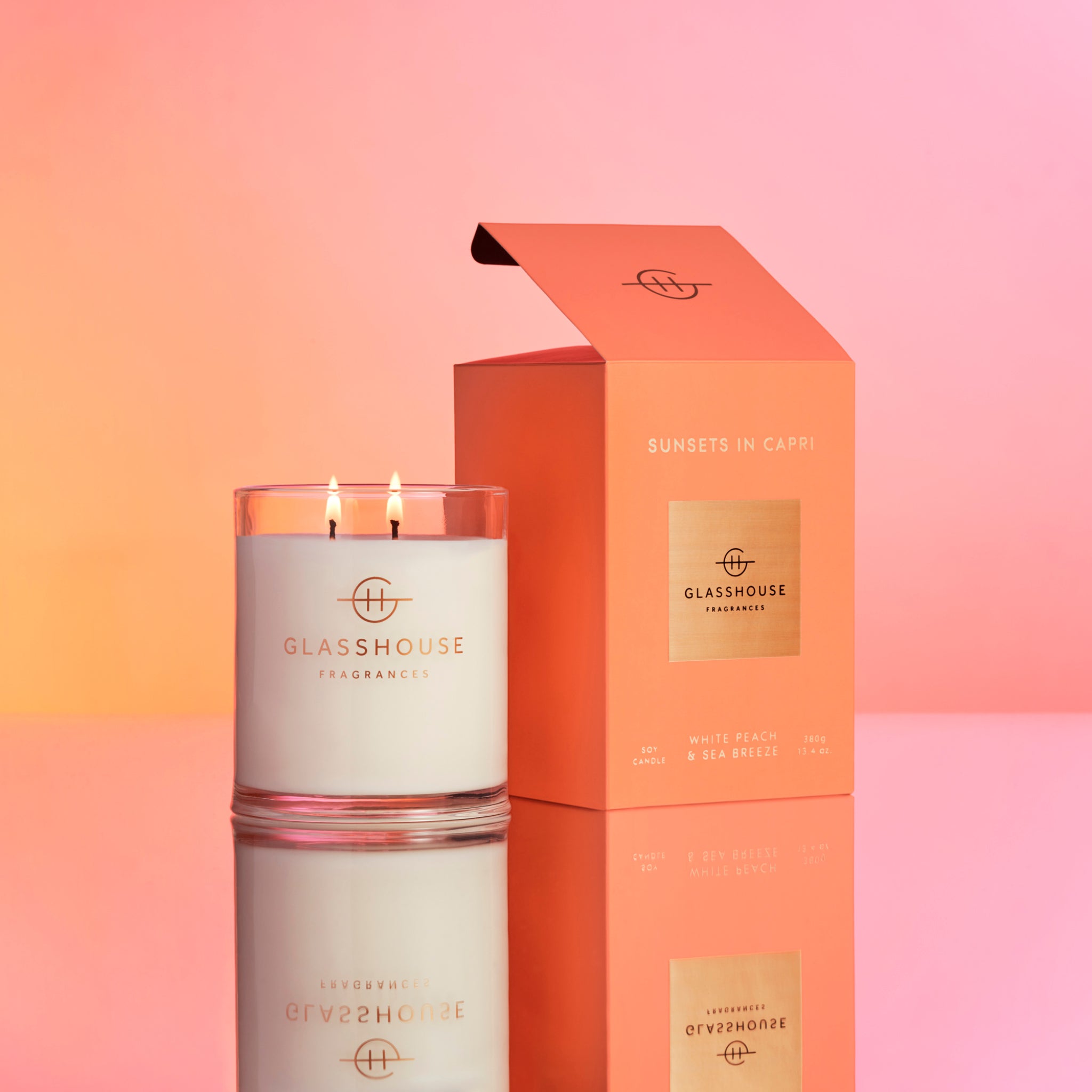 Burning Glasshouse Fragrances Sunsets In Capri Soy Candle on sunset orange-pink background